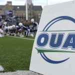 OUA football power rankings featured image showing an OUA field marker on the sideline with a Canadian university football game in the background.
