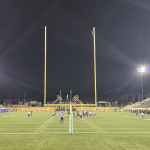 CFL football game at Hamilton Stadium under the lights, with players lined up on the field and fans in the stands.